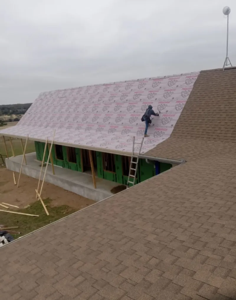 Worker preparing underlayment for a metal roof installation in Chester